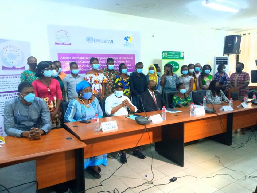 Des personnes masquées posent pour une photo lors d’un atelier autour d’une grande table en salle de réunion