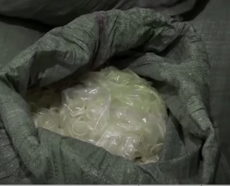 Sac ouvert contenant plusieurs préservatifs en vrac transparents et emballés dans un plastique transparent