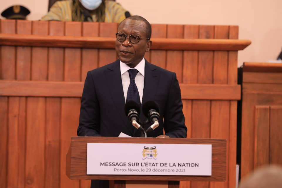 Homme en costume sombre prononçant un discours derrière un pupitre avec inscription sur l’état de la nation