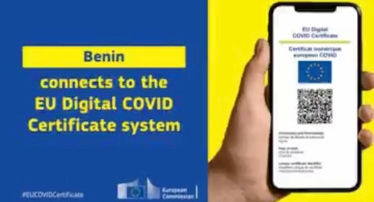 Main tenant un smartphone avec un certificat numérique Covid-19 affiché à côté d’un texte en anglais sur fond bleu et jaune