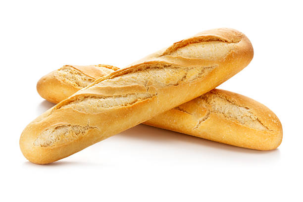 Trois baguettes de pain frais posées les unes sur les autres sur un fond blanc