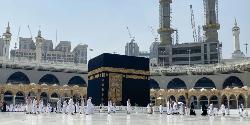 De nombreux pèlerins en tenue blanche accomplissent le tawaf autour de la Kaaba au sein de la grande mosquée.