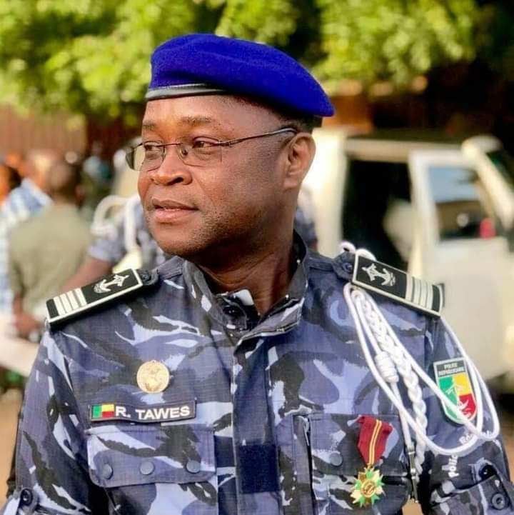 Homme en uniforme militaire bleu camouflage et béret bleu regardant vers la gauche avec des décorations sur la poitrine