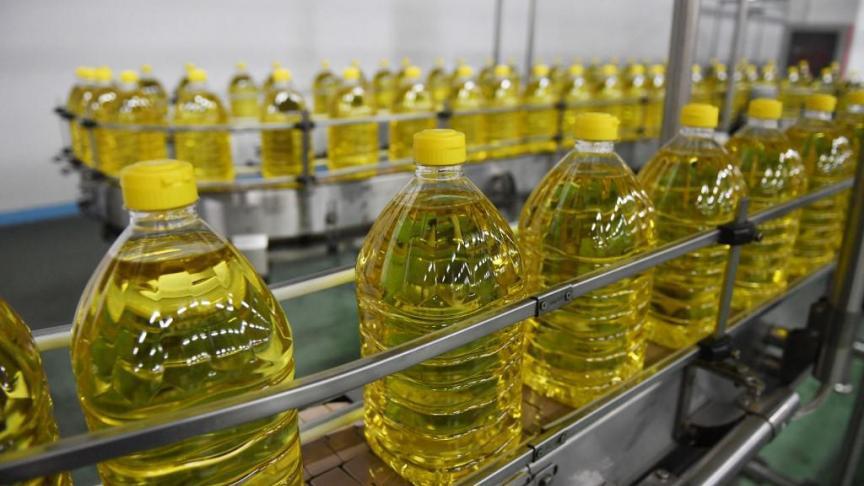 Bouteilles d’huile alimentaire conditionnées sur une chaîne de production dans un atelier industriel
