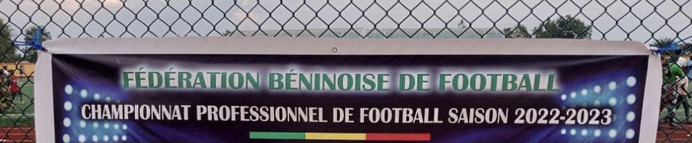 Banderole indiquant Fédération Béninoise de Football et Championnat Professionnel de Football saison 2022-2023, fixée sur une clôture en grillage