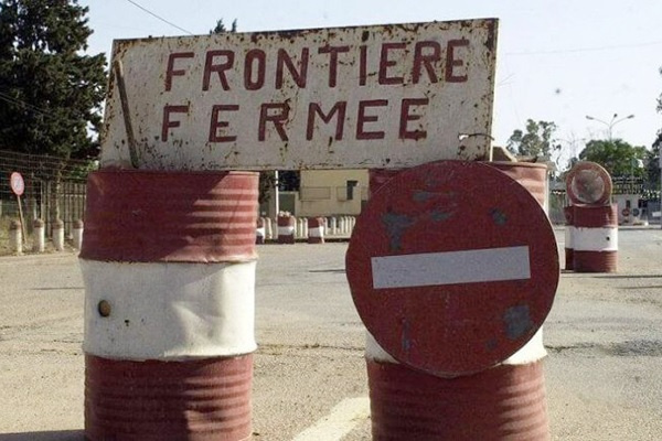 Barrières et panneau de signalisation indiquant la fermeture d'une route ou frontière sur une chaussée désertée