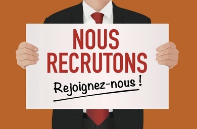 Personne en costume tenant une pancarte avec le texte nous recrutons rejoignez-nous sur fond orange