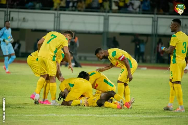 Des joueurs en tenue jaune célèbrent un but sur le terrain tout en étant entourés de coéquipiers lors d’un match de football