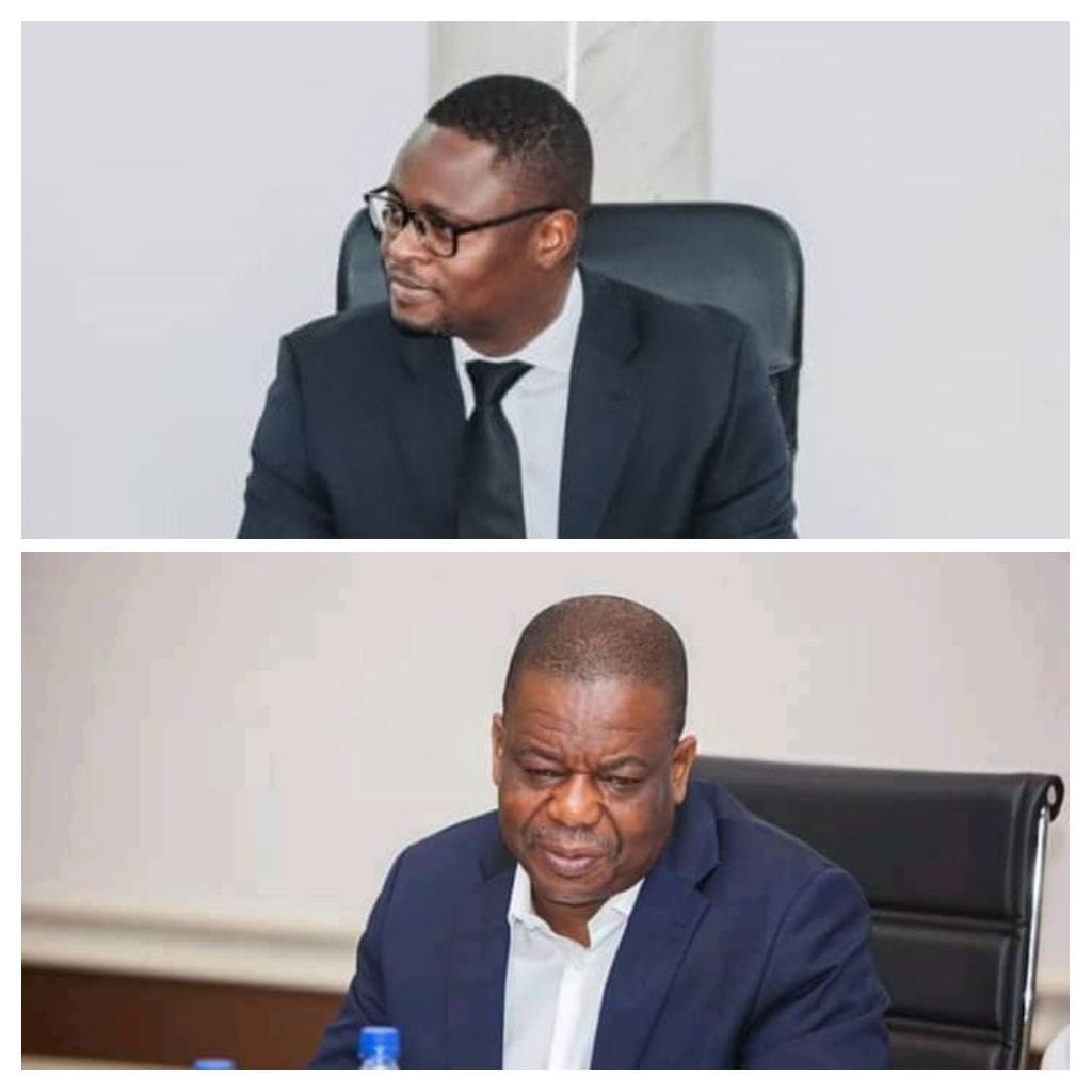 Deux hommes en costume assis à des bureaux regardant dans des directions opposées dans une pièce claire
