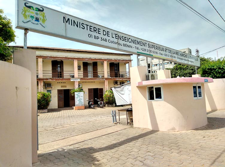 Entrée d’un bâtiment administratif avec un grand panneau indiquant un ministère de l’enseignement supérieur et de la recherche
