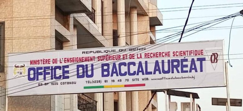 Bannière du ministère de l'enseignement supérieur et de la recherche scientifique avec mention de l'Office du Baccalauréat suspendue entre des bâtiments.