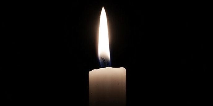 Bougie allumée sur fond noir avec une flamme brillante au centre de l image