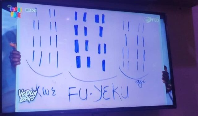 Deux mains tiennent un tableau blanc avec des dessins et les mots KWÈ FU-YÈKU écrits en bleu au centre