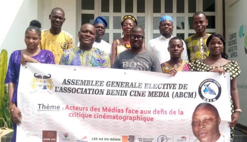 Groupe de dix personnes posant derrière une banderole lors d’une assemblée générale d’une association de médias cinématographiques