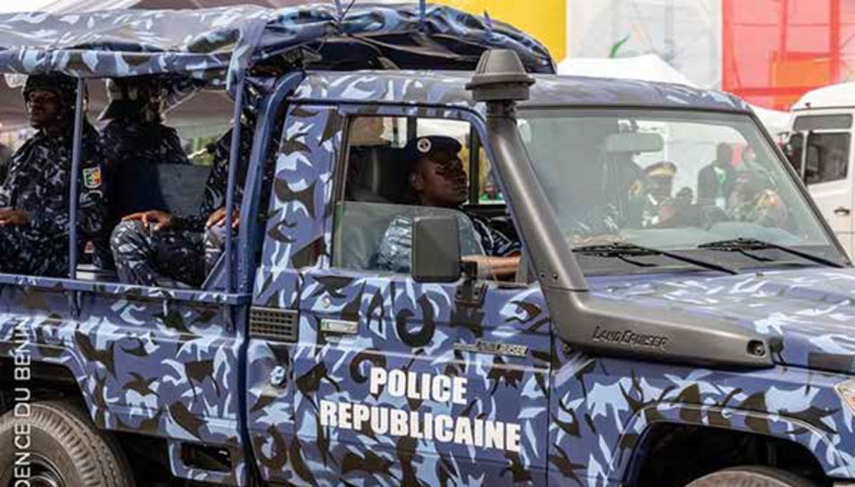 Véhicule de police républicaine avec deux agents en uniforme à bord dans une rue urbaine colorée