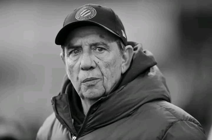 Homme âgé portant une casquette et une veste d'hiver regardant devant lui avec une expression sérieuse