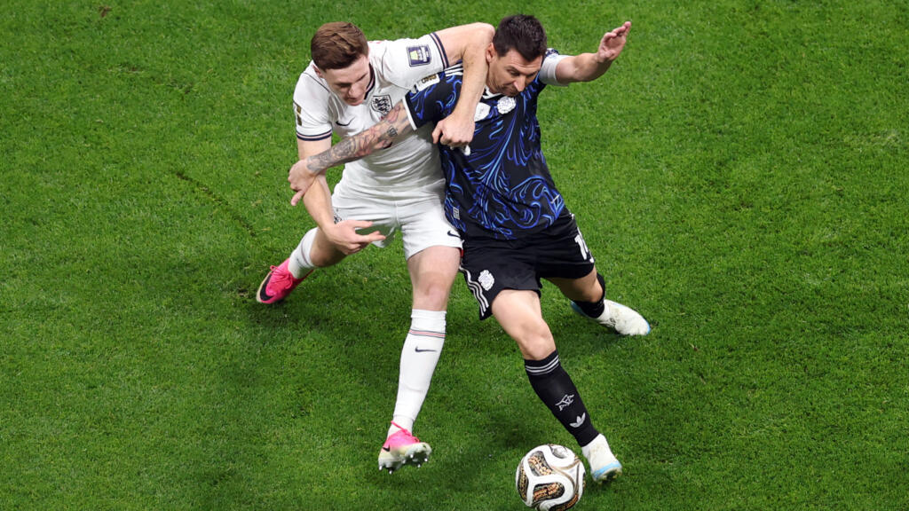 Deux joueurs de football se disputent le ballon sur le gazon pendant un match intense
