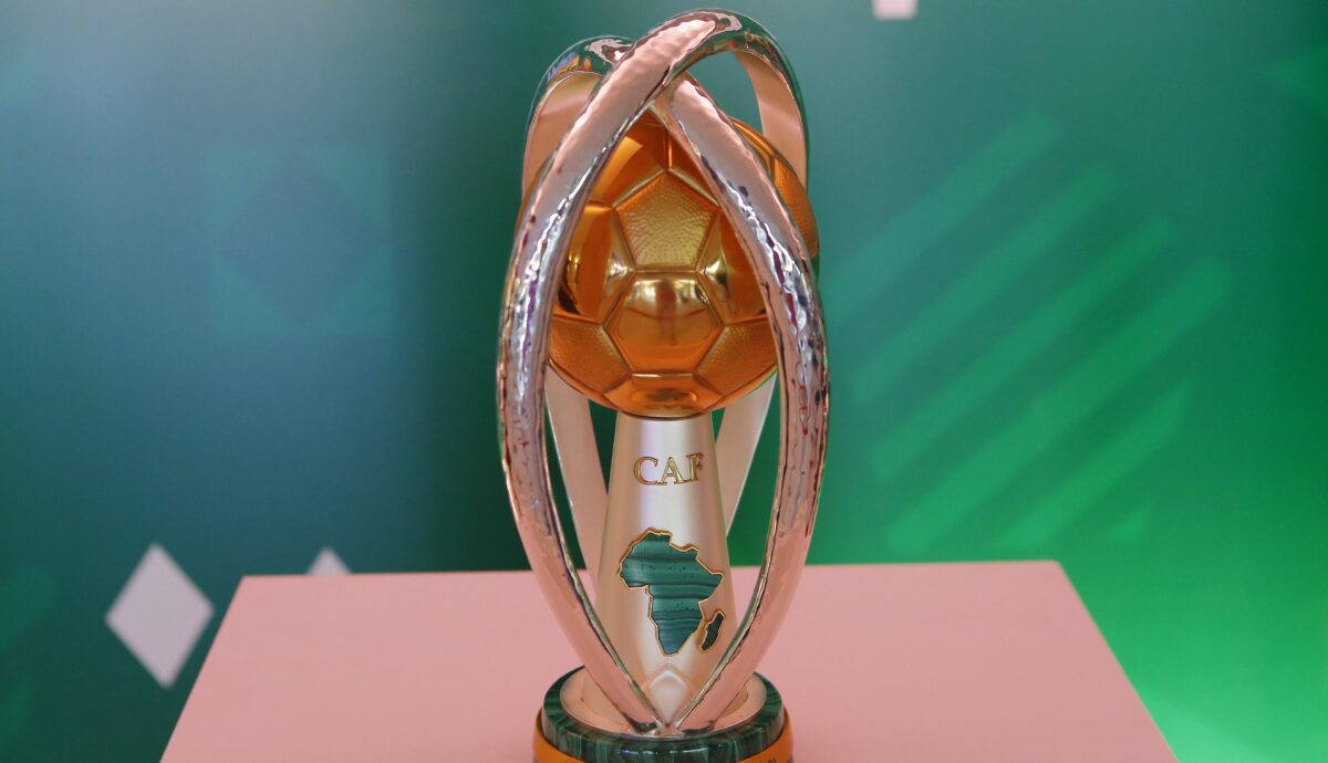Trophée doré à la forme moderne avec une carte de l'Afrique sur un socle noir devant un fond vert flou